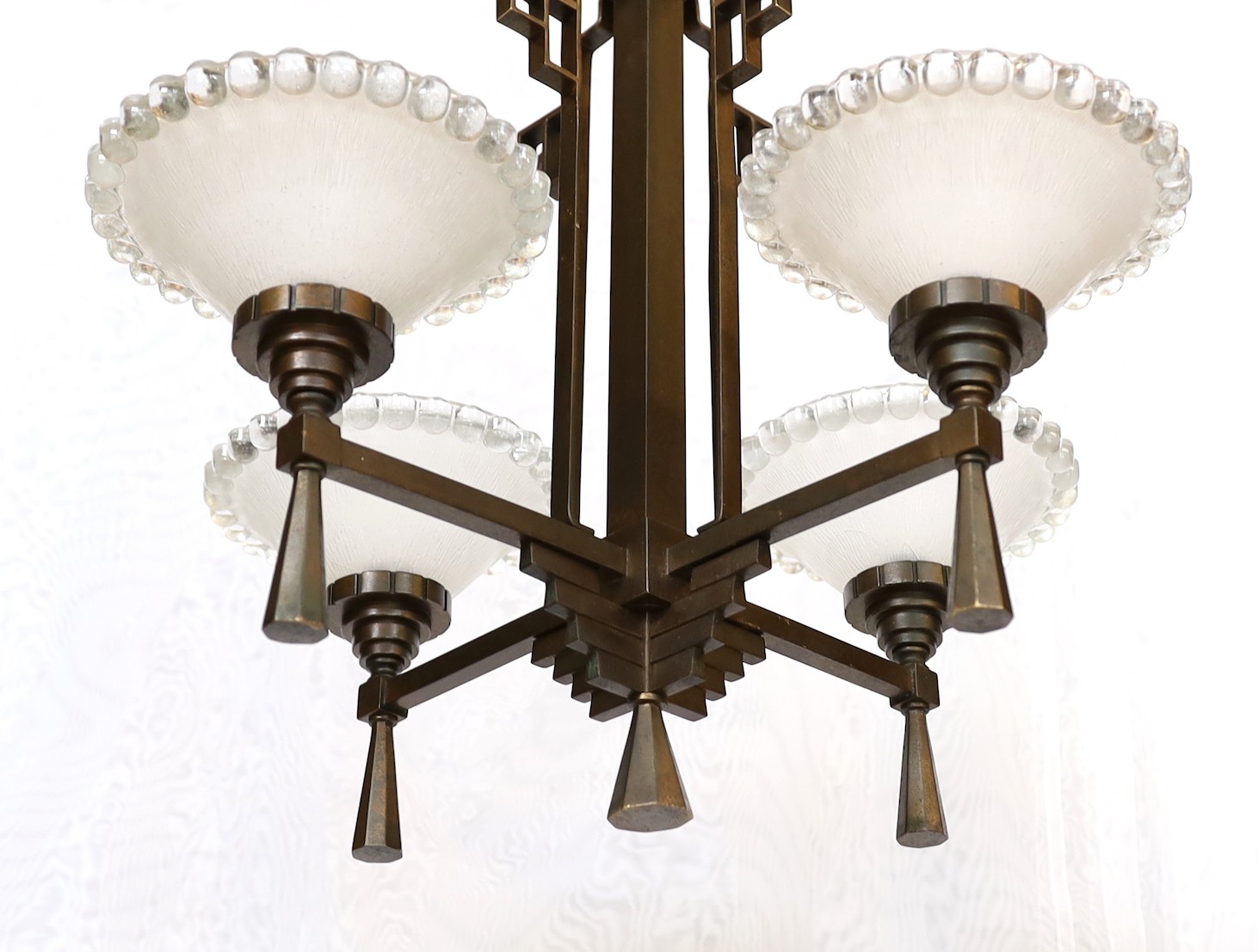 An Art Deco bronze and glass light fitting with four beaded frosted shades. height 81cm. width 54cm